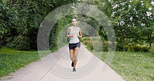 Cheerful woman running in park