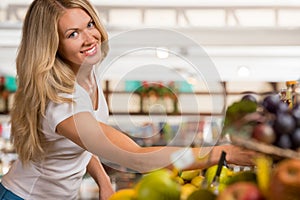 Cheerful woman shopping at organic food store