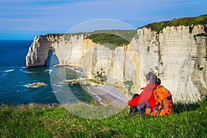 Cheerful woman sitting and enjoying the view, Etretat, Normandy, France