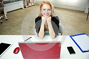 Cheerful woman sitting at her work place