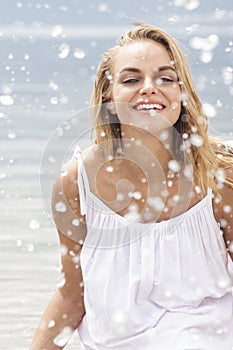 Cheerful woman splashing water on the beach