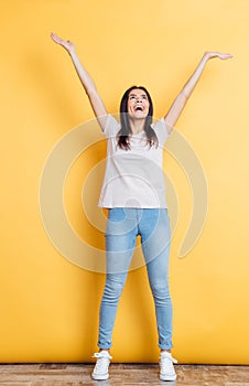 Cheerful woman standing with raised hands