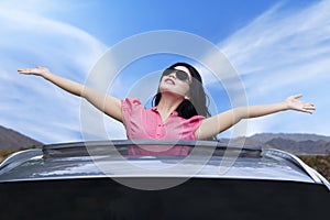 Cheerful woman standing on the sunroof photo