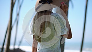 Cheerful woman in sun hat walking outdoor