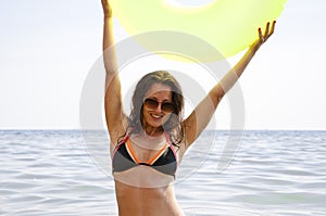 Cheerful woman suntan in sea water on inflatable ring