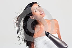 Cheerful woman in towel drying her hair