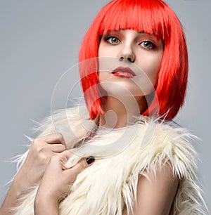 Cheerful woman in white fake fur coat in hot red party wig