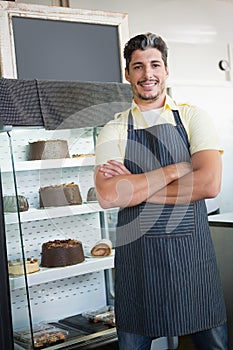 Cheerful worker posing with arms crossed
