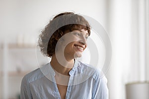 Cheerful young 35s woman laughing looking in distance.