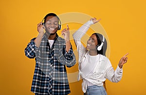 Cheerful young african american couple friends dancing and singing in spare time favorite music