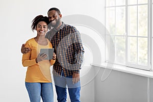 Cheerful young african american family hugging, enjoy move and planning new interior