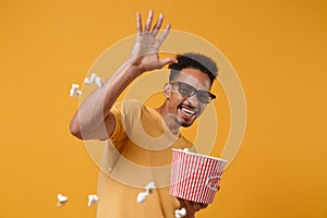 Cheerful young african american guy in 3d imax glasses posing isolated on yellow orange background. People lifestyle photo