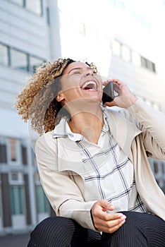 Cheerful young african american woman talking on cellphone and laughing