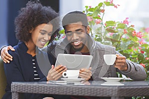 Cheerful young african couple shopping online with tablet