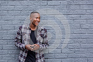 Cheerful young african guy with a cell phone looking away and sm