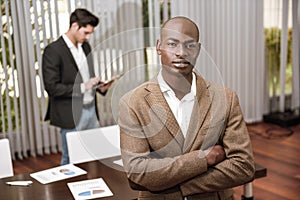 Cheerful young African man in formalwear keeping arms crossed