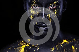 Cheerful young african woman with art fashion makeup. An amazing woman with black makeup and leaking yellow paint