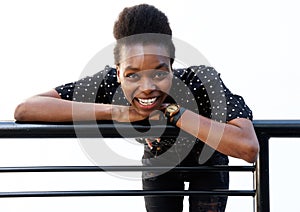 Cheerful young african woman leaning on railing