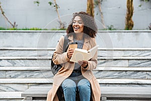 Cheerful young african woman wearing coat walking