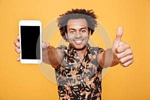 Cheerful young afro american man showing blank screen mobile phone