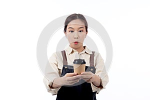 Cheerful young asian woman barista in casual work attire happily holding a takeaway coffee cup.