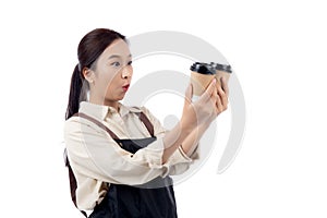 Cheerful young asian woman barista in casual work attire happily holding a takeaway coffee cup.