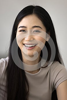 Cheerful young Asian woman head shot vertical portrait