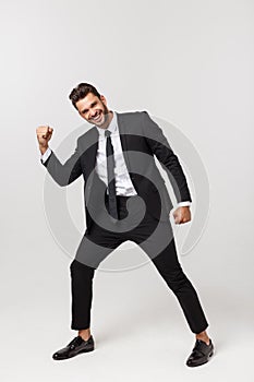 Cheerful young bearded business man show hand up excited with clenched fists. Full length portrait business man isolated