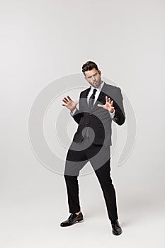 Cheerful young bearded business man show hand up excited with clenched fists. Full length portrait business man isolated