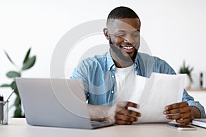 Cheerful Young Black Entrepreneur Working With Papers In Modern Office