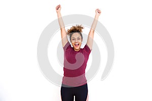 Cheerful young black woman smiling with arms raised against white background