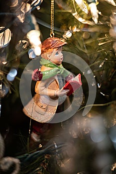 Cheerful young boy's Christmas decoration on a tree adorned with colorful decorations