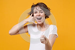 Cheerful young brunette woman girl in white t-shirt isolated on yellow background. People lifestyle concept. Mock up
