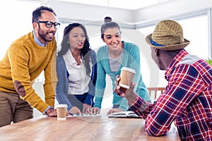 Cheerful young business people discussing at creative office