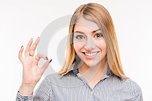 Cheerful young businesswoman gesturing `OK`, close up photo