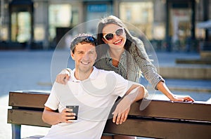 Cheerful young couple on a bench.