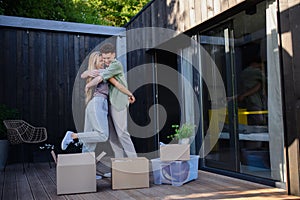 Cheerful young couple moving in their new tiny house in woods. Conception of moving and sustainable living. photo