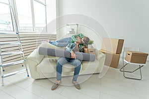 Cheerful young couple rejoices in moving to a new home laying out their belongings in the living room. Concept of