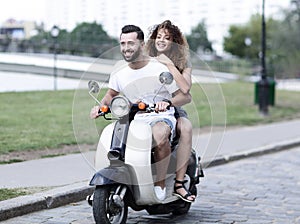 Happy cheerful couple riding vintage scooter. Travel concept.