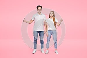 Cheerful young couple showing thumbs up