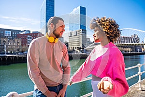 Cheerful young couple in vibrant outfits enjoying some quality time together outdoors in urban area