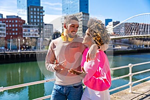 Cheerful young couple in vibrant outfits enjoying some quality time together outdoors in urban area