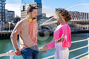 Cheerful young couple in vibrant outfits enjoying some quality time together outdoors in urban area