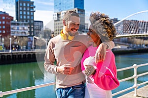 Cheerful young couple in vibrant outfits enjoying some quality time together outdoors in urban area