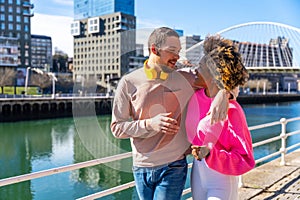 Cheerful young couple in vibrant outfits enjoying some quality time together outdoors in urban area