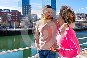 Cheerful young couple in vibrant outfits enjoying some quality time together outdoors in urban area