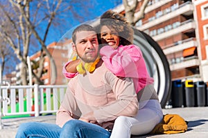 Cheerful young couple in vibrant outfits enjoying some quality time together outdoors in urban area