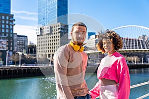 Cheerful young couple in vibrant outfits enjoying some quality time together outdoors in urban area