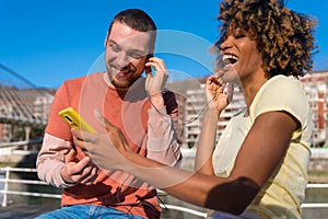 Cheerful young couple in vibrant outfits enjoying some quality time together outdoors in urban area