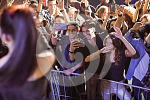 Cheerful young crowd photographing performer at nightclub